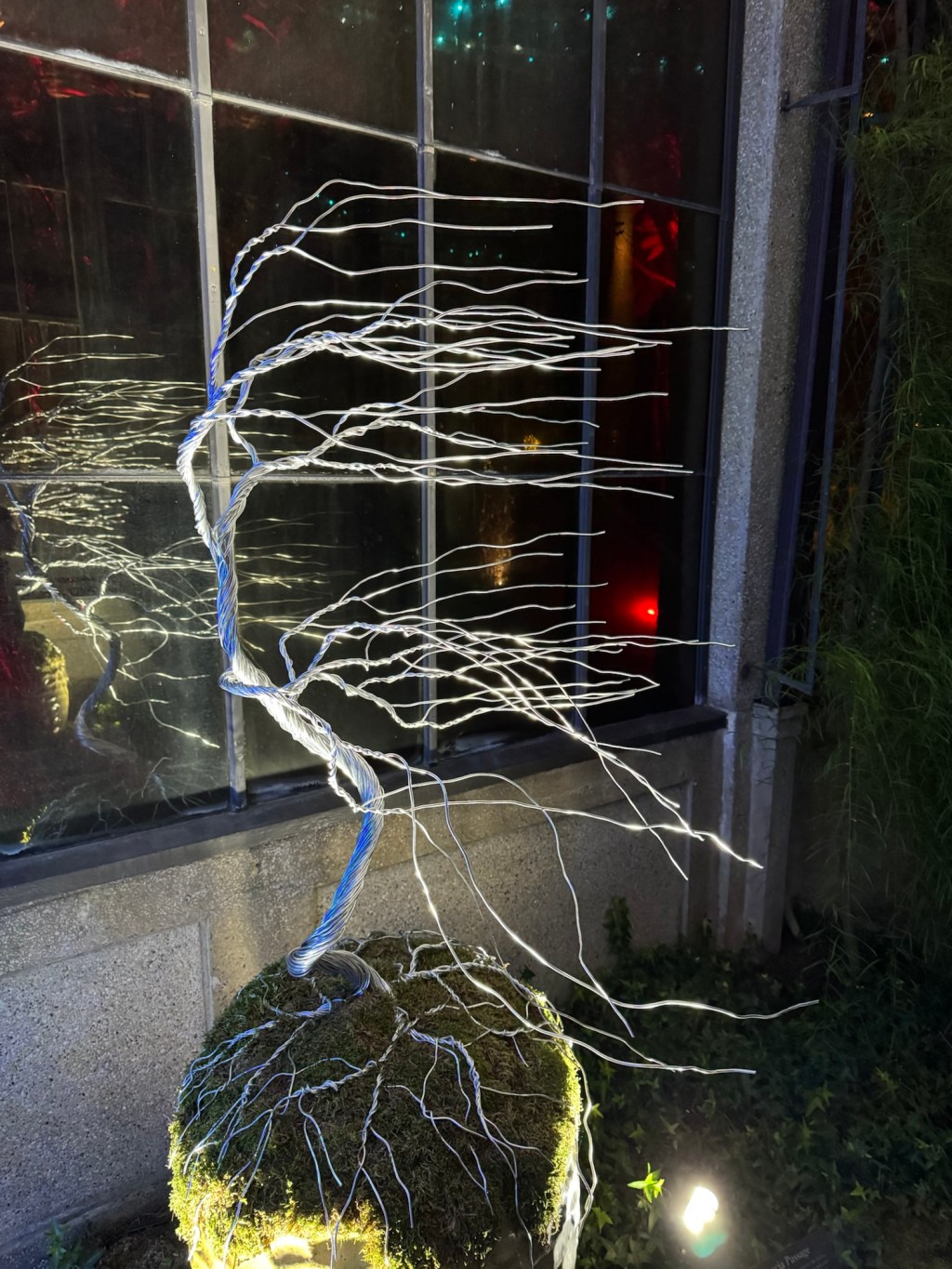 sculpture of a tree whose branches are blown by a strong wind